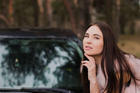 Portrait of a very beautiful girl in a forest dressed in fur in a carの写真素材