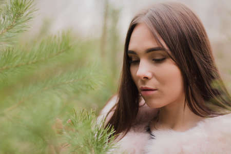 Portrait of a very beautiful girl in a forest dressed in furの写真素材