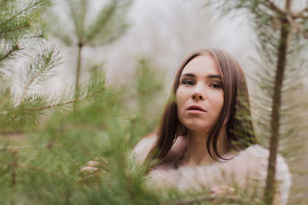 Portrait of a very beautiful girl in a forest dressed in furの写真素材