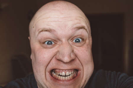 Scary expression with bulging eyes and bald head.の写真素材