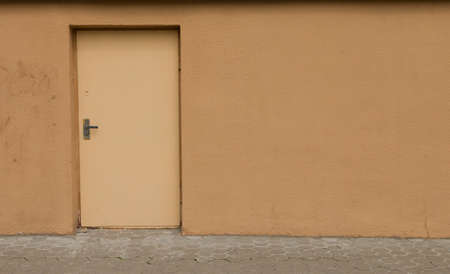 Old door on a yellow wall in an abandoned building.の写真素材