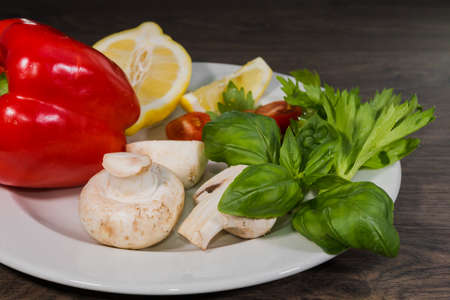 Parsley, lemon, pepper champignons on a plateの写真素材
