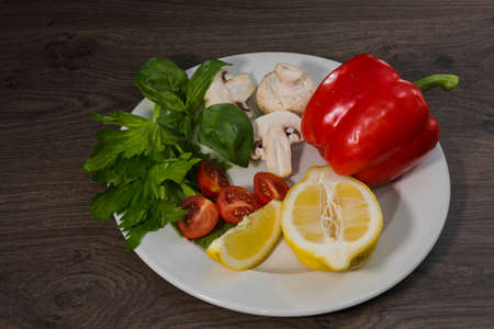 Parsley, lemon, pepper champignons on a plateの写真素材