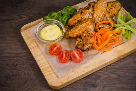 Fried chicken wings with sauce and salad.の写真素材