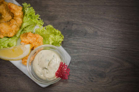 Fried prawns on a plate with sauce and on a wooden background.の写真素材