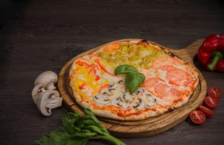 Hot piece of pizza with melted cheese on a rustic wooden table.の写真素材