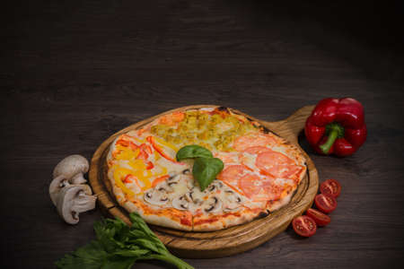 Hot piece of pizza with melted cheese on a rustic wooden table.の写真素材