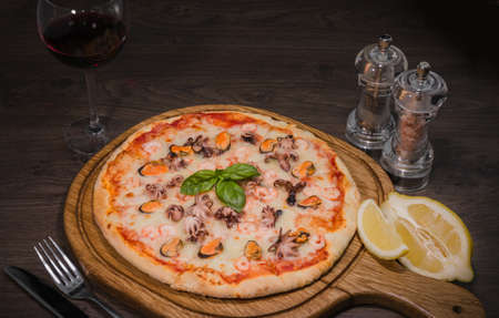 Hot piece of pizza with melted cheese on a rustic wooden table.の写真素材