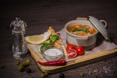 Soup on a wooden background with white bread and sauce.の写真素材
