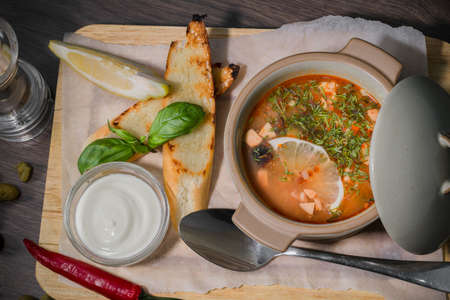 Soup on a wooden background with white bread and sauce.の写真素材