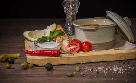 Soup on a wooden background with white bread and sauce.の写真素材