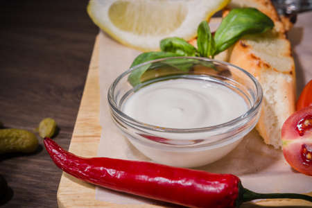Soup on a wooden background with white bread and sauce.の写真素材