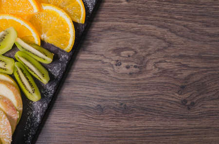 Fruit slicing on a wooden background and on a stone stand.の写真素材