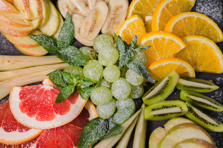 Fruit slicing on a wooden background and on a stone stand.の写真素材