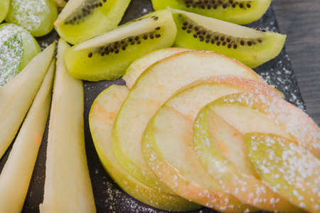 Fruit slicing on a wooden background and on a stone stand.の写真素材