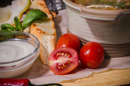 Soup on a wooden background with white bread and sauce.の写真素材