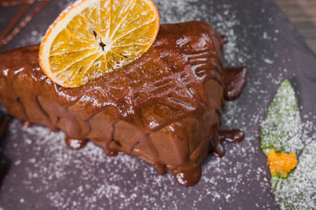 Chocolate dessert with orange chips on a wooden background.の写真素材