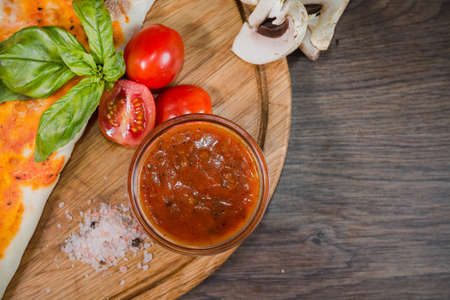 Hot piece of pizza with melted cheese on a rustic wooden table.の写真素材
