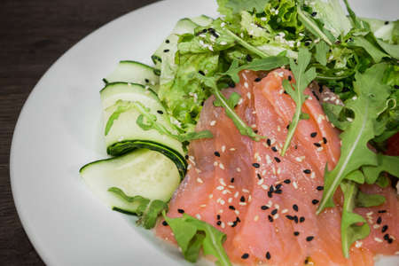 Meat of trout on a plate with vegetables and grapefruit.の写真素材