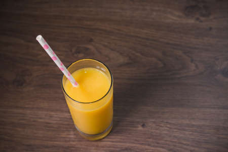 Fresh cold juice in a glass with a straw.の写真素材