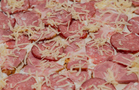 Sausage with meat on dough with mayonnaise and cheese, pizza preparationの写真素材
