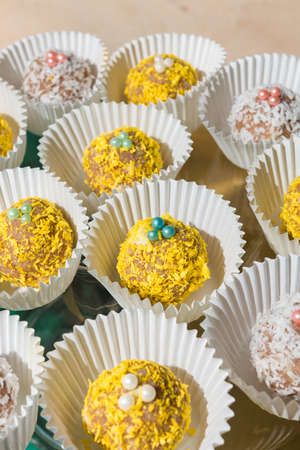 Yellow and white cakes in white cups on a glass stand