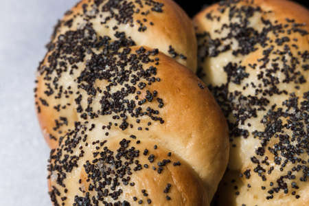 Buns with poppy seeds on a black plate and blue napkin