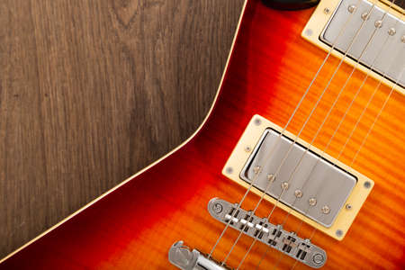 Old beautiful electric guitar on a background of wood