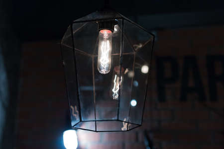 An ancient lamp burns in a chandelierの写真素材