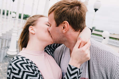 Two lovers walk around the park, kiss and hug, a love story.