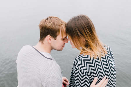 Two lovers walk around the park, kiss and hug, a love story.