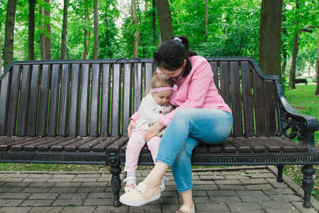 Happy mother and her children are walking in the park on a sunny dayの写真素材