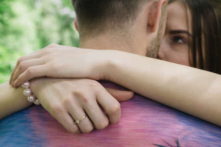 Young couple hugging and smiling at each other in the parkの写真素材