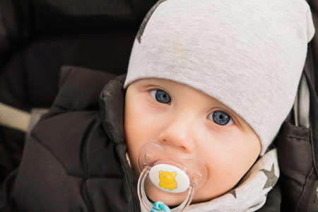 A baby in a wheelchair and smiling