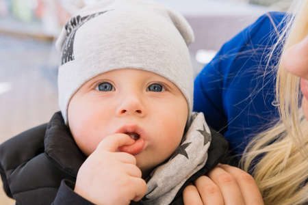 A happy married couple is sitting in a cafe and enjoying this time. They play with their child, he smiles.の写真素材