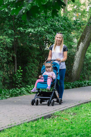 Mother walking while pushing a stroller in the park