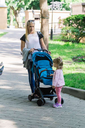 Mother walking while pushing a stroller in the park