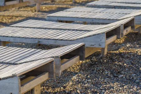 Wooden chaise lounge on the beach on a sunny day.の写真素材