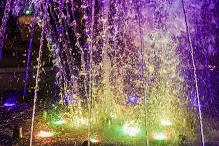 Musical fountain with colorful illumination at night with reflection.の写真素材