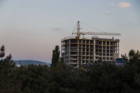 Tall Building Under Construction Under Cloudy Sunset.