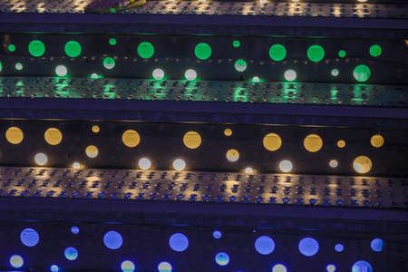 Bright colored lamps on carousels at night.