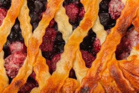 Berry pie on a wooden background with ingredients.