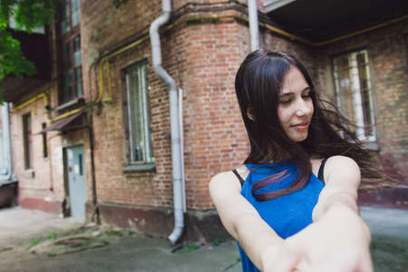 A very beautiful and cheerful girl stands on the street with long, luxurious hairの写真素材