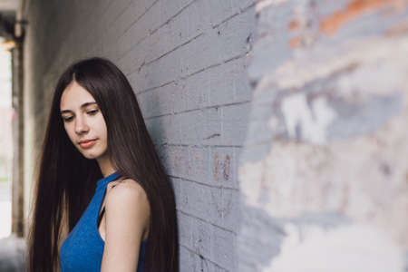 A very beautiful and cheerful girl stands on the street with long, luxurious hairの写真素材