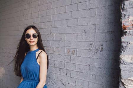 A very beautiful and cheerful girl stands on the street with long, luxurious hairの写真素材