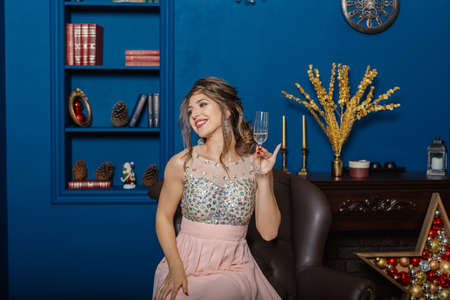 Very beautiful woman drinking champagne in new year decor.の写真素材