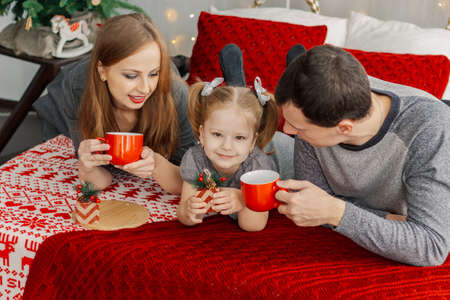 Happy family on bed on a bright Christmas morning. New Year 2019.の写真素材