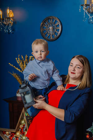 Portrait of happy mother and adorable baby celebrate Christmas. New Years holidays. Toddler with mom in the festively decorated room with Christmas tree and decorations.の写真素材