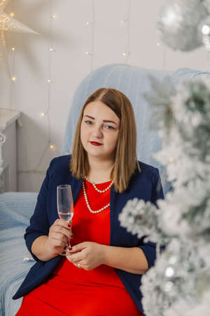 Very beautiful woman drinking champagne in new year decor.の写真素材