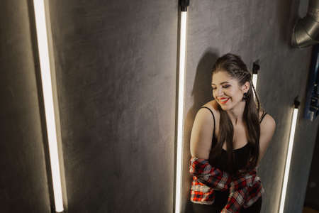 Beautiful and sexy girl posing for a photographer on the black iron stairs with lamps in a cafe.の写真素材